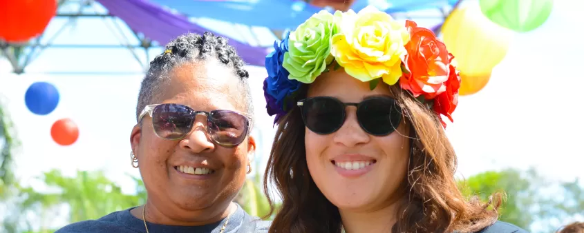 A photo capturing community members at a local pride celebration, highlighting diverse faces and an inclusive atmosphere